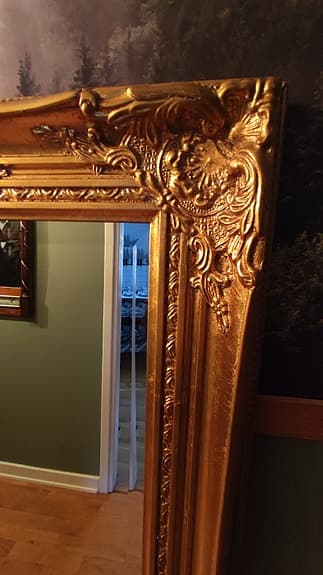 Spegel med guldfärgad ornamenterad ram