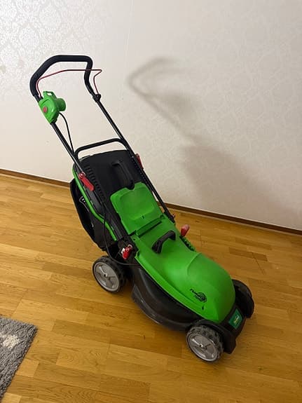 Grön elektrisk gräsklippare med uppsamlare