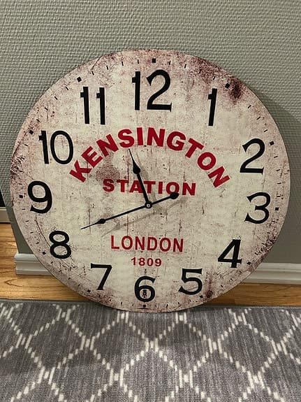 Jysk väggklocka rund vit med svart och röd text