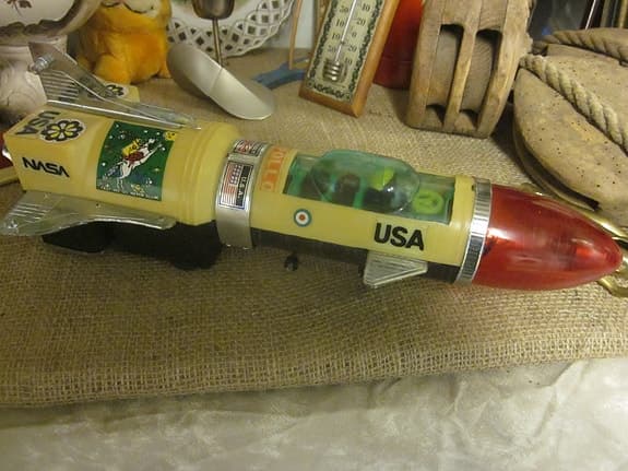 Raketformad rymdleksak med USA-motiv  i metall och plast. Troligt 1960 tal.