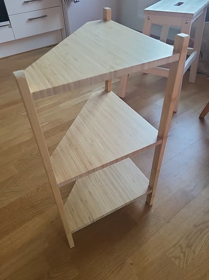 Hörnhylla i ljust trä med tre hyllplan