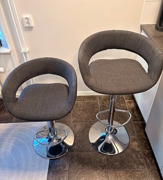 2 st tygbeklädda barstolar med sits i grått och ben i silver.