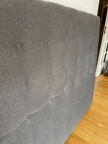Sänggavel i grått tyg