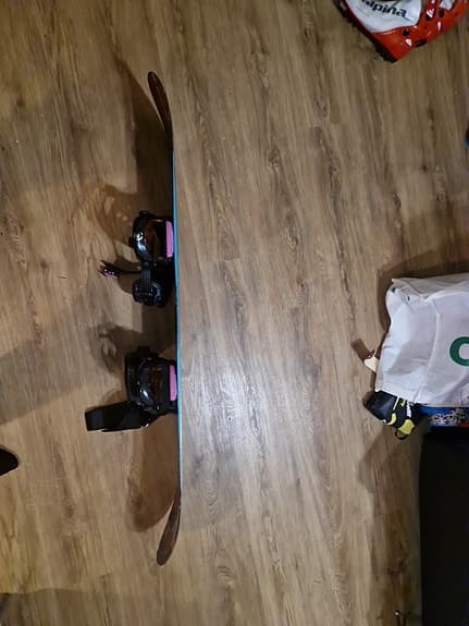 K2 snowboard med bindningar och blå snowboardboots