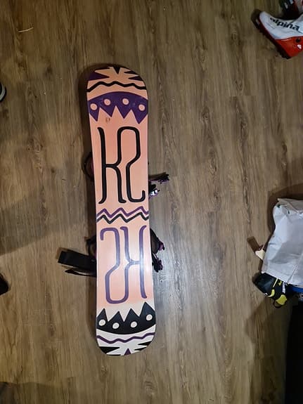 K2 snowboard med bindningar och blå snowboardboots