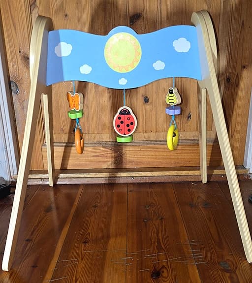 Bigjigs babygym i trä med en skinande sol och färgglada hängen
