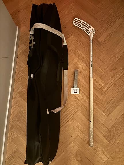 Unihoc innebandyklubba vit, plus ett svart fodral från unihoc