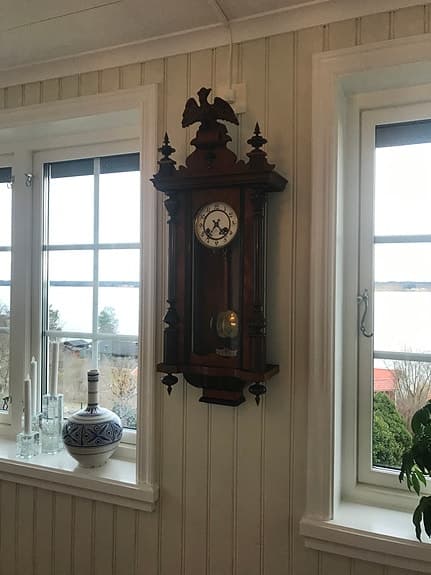 Väggpendyl i mörkt trä med slagverk