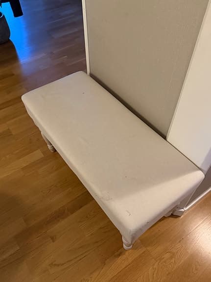 Fin sängpall med vitpigmenterade svarvade ben