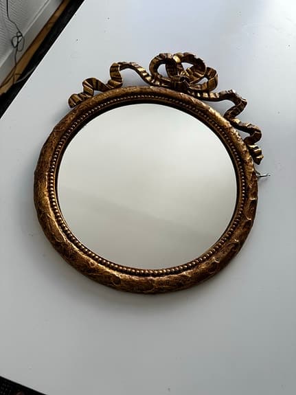 Rund spegel i rokokostil med dekorativ guldfärgad ram