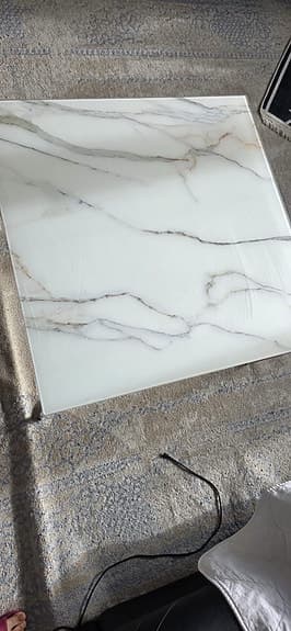 Soffbord med marmor glasskiva som en design på toppen och silver ben i metall.