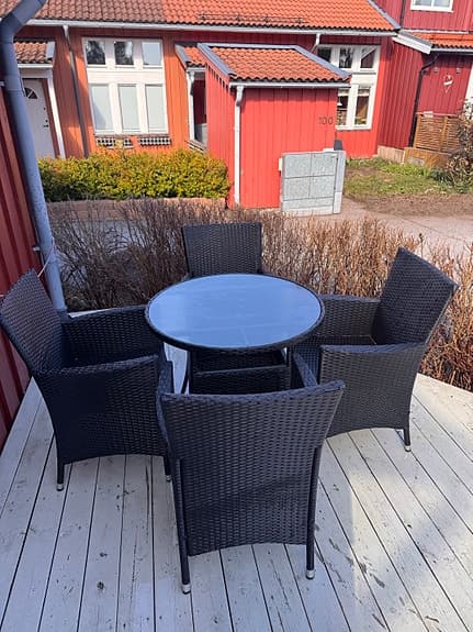 Matgrupp ute rund bord med fyra stolar svart konstrotting