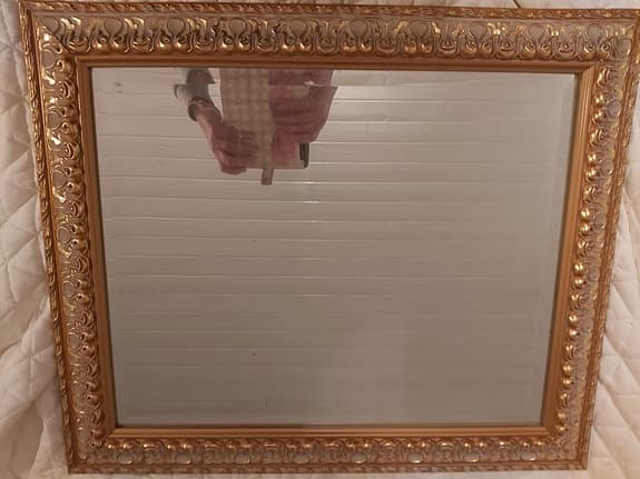 äldre spegel med dekorativ guldram