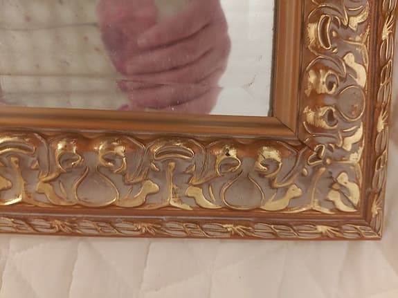 äldre spegel med dekorativ guldram