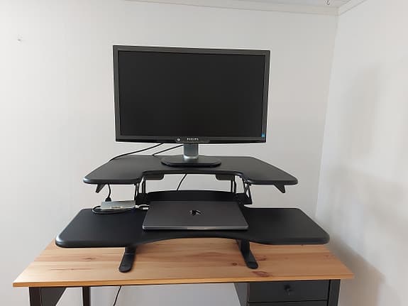 Svart höj- och sänkbar skrivbordsställning för skärm och laptop