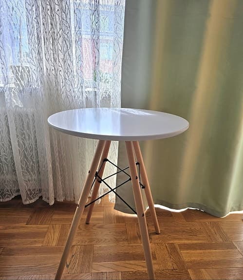 Runt bord med vita skiva och träben