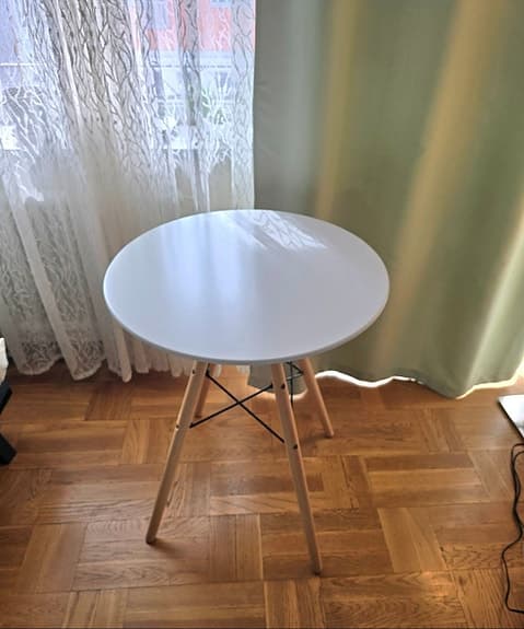 Runt bord med vita skiva och träben