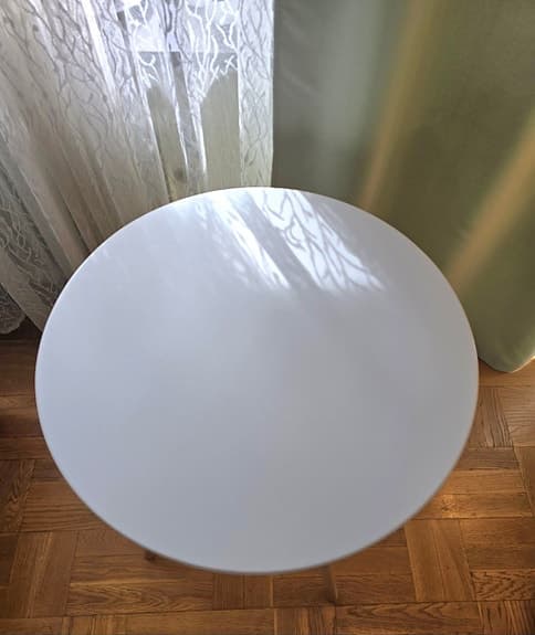 Runt bord med vita skiva och träben