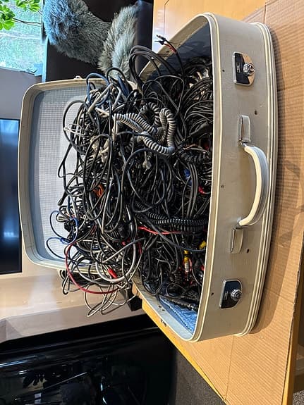 Blandade kablar och sladdar i resväska