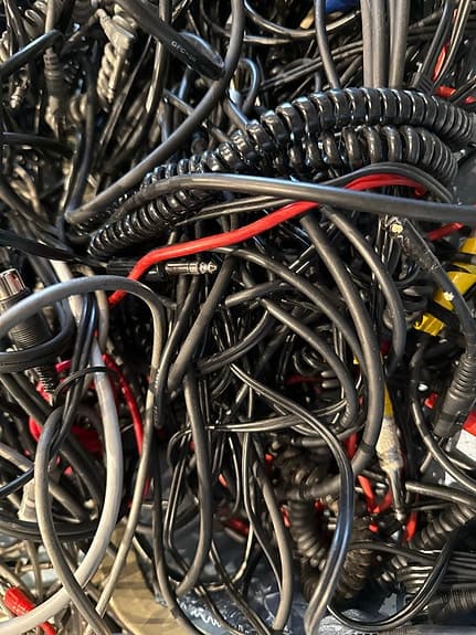 Blandade kablar och sladdar i resväska