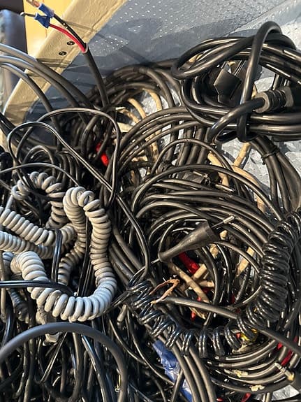 Blandade kablar och sladdar i resväska