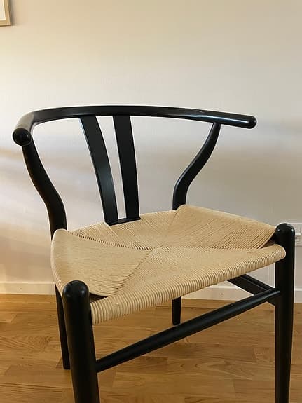Svart karmstol med flätad sits