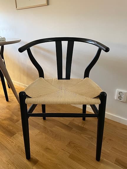 Svart karmstol med flätad sits