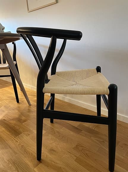 Svart karmstol med flätad sits