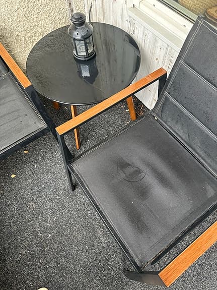 Cafeset två stolar, två-sits sofa med gråa dynor och runt bord svart