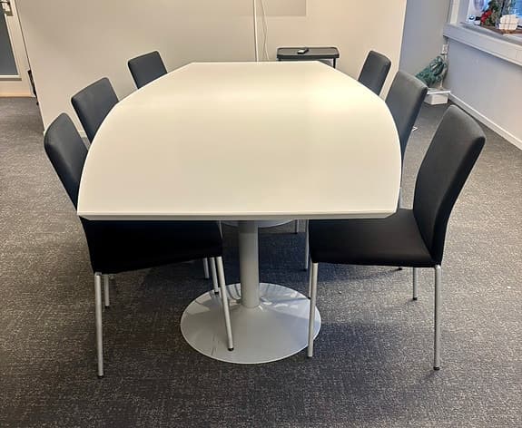 Konferensbord med stolar och grå fåtölj