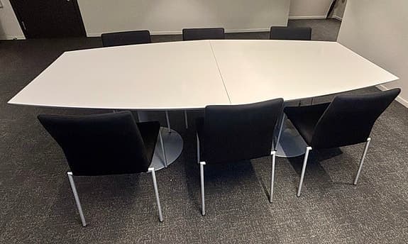Konferensbord med stolar och grå fåtölj
