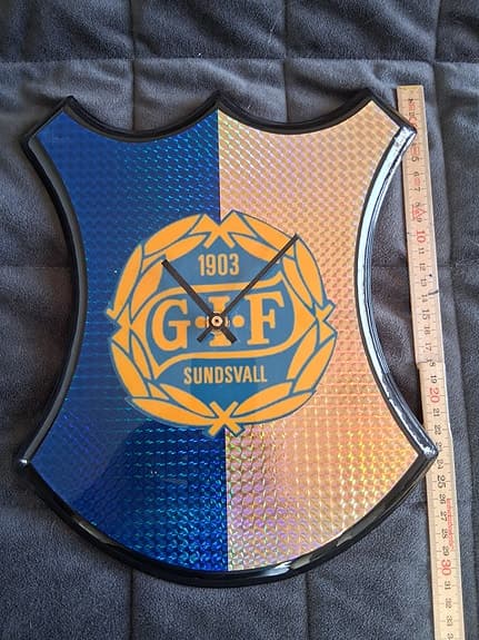 GIF Sundsvall väggklocka sköldformad blå och gul