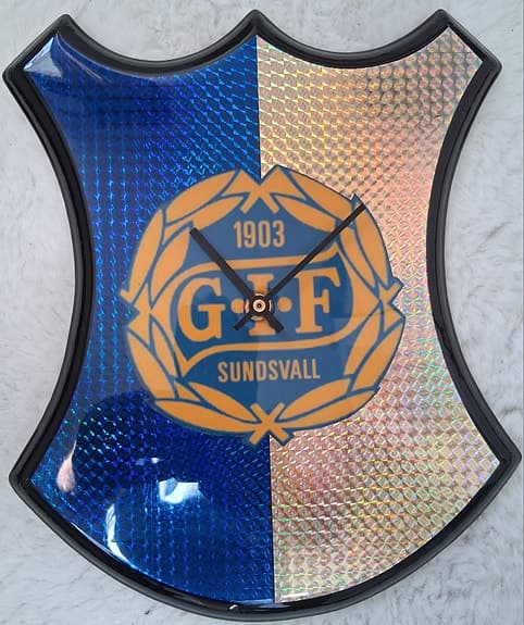 GIF Sundsvall väggklocka sköldformad blå och gul