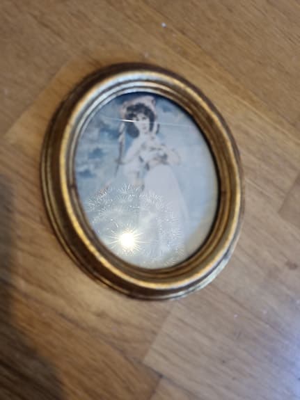 Oval ram med motiv i guldton