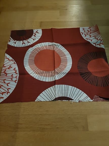 Mönstrat tygstycke rött vitt runt motiv