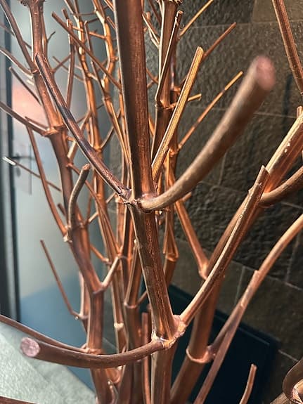 Dekorationsvas med konstgjorda grenar kopparfärg