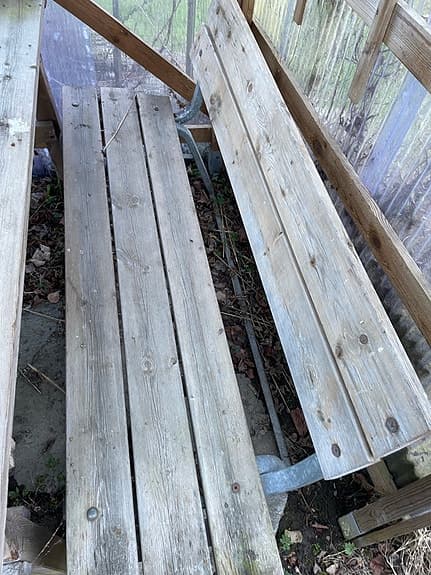 Träbänk utomhus med ryggstöd och metallstativ