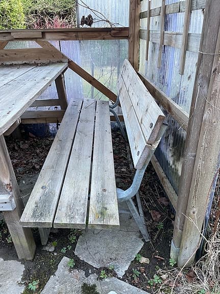 Träbänk utomhus med ryggstöd och metallstativ