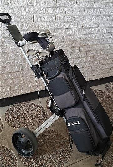 Golfklubbor med bag och vagn.
