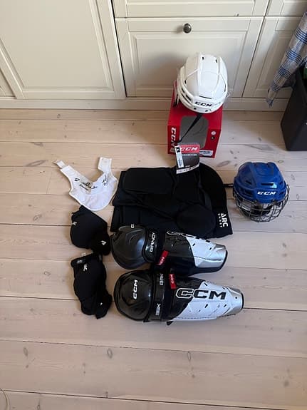 CCM ishockeyutrustning set hjälmar benskydd skydd svart vit blå