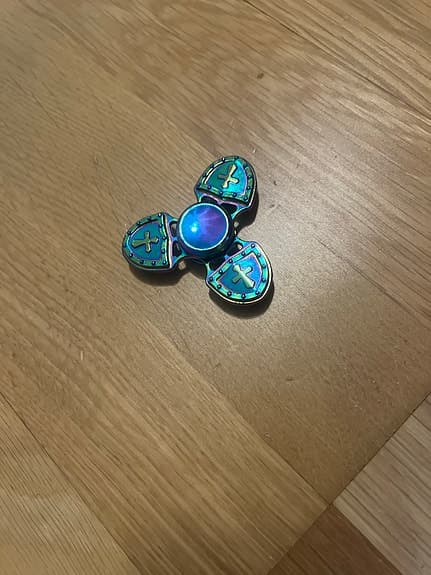 Fidget spinner metall flerfärgad med sköldmotiv
