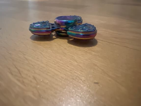 Fidget spinner metall flerfärgad med sköldmotiv