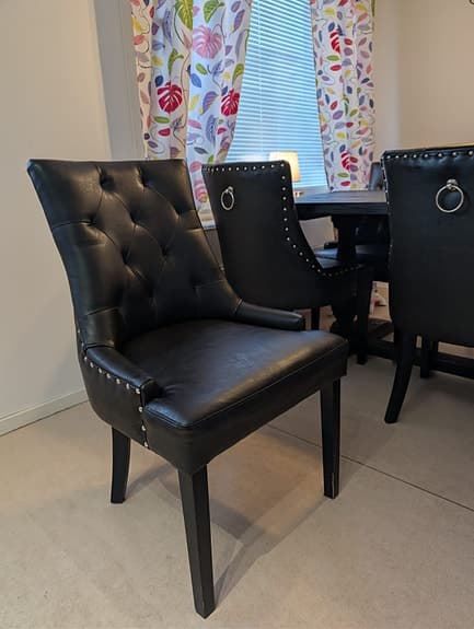 Matbord med 6 svarta stolar i trä och konstläder