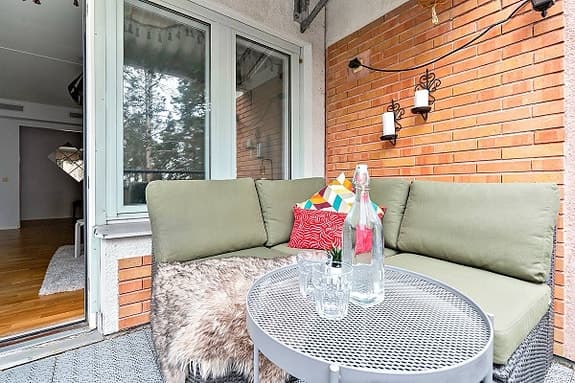 Hörsoffa för balkong med gröna dynor och runt bord