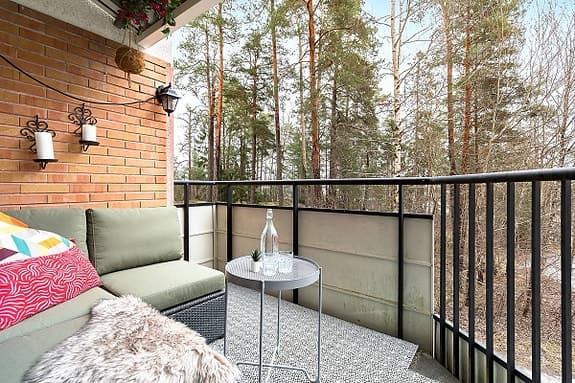 Hörsoffa för balkong med gröna dynor och runt bord