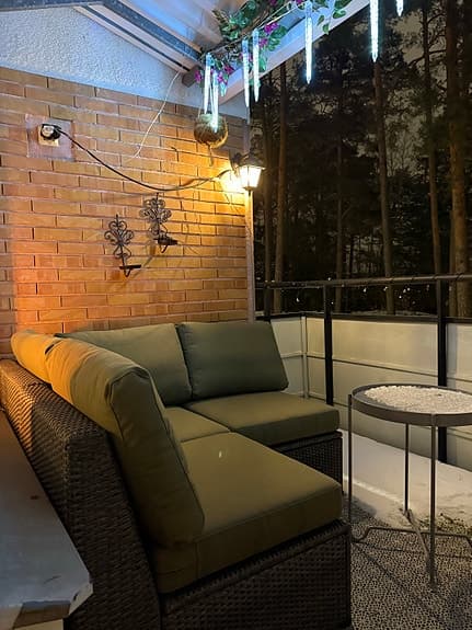 Hörsoffa för balkong med gröna dynor och runt bord