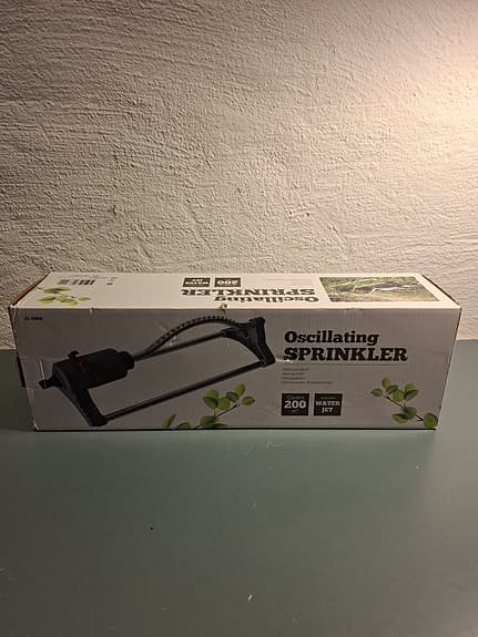 Trädgårdsslang på vagn med oscillernade vattenspridare