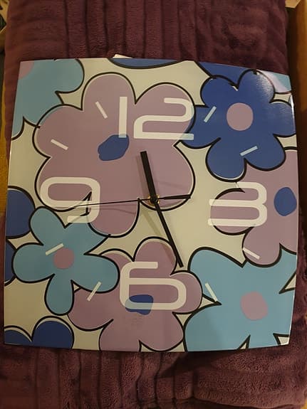 Väggklocka i glas med blommotiv