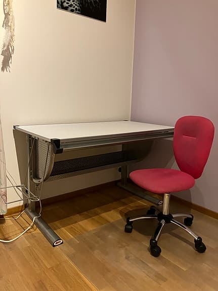 Ställbart skrivbord och skrivbordsstol.