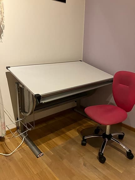 Ställbart skrivbord och skrivbordsstol.